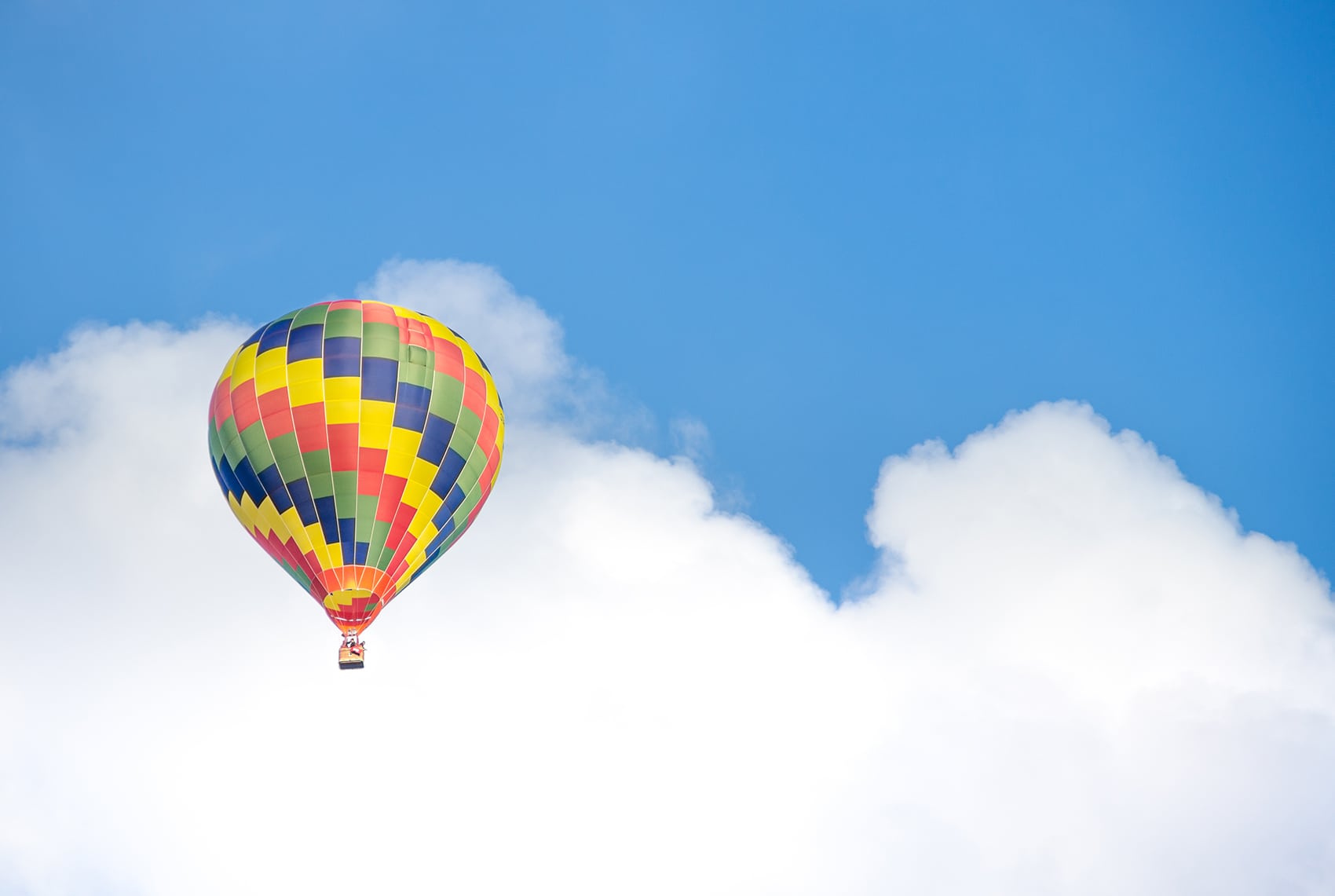 Luftballon på en blå himmel med skyer som metafor for cloud