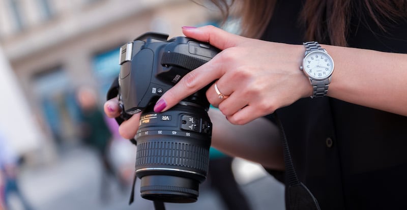 Fotograf med kamera klar til en udendørs optagelse